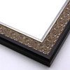 An ornate, solid wood frame featuring an intricate design overlaid with elegant silver leaf, and lightly antiqued.  A shallow scooped profile and unadorned inner edge draw the eye inward. A dark brown outer edge highlights the design.  

1.75 " width: ideal for medium-sized artworks.  Oil paintings, prints and formal family photos will be equally at home encased in this traditional frame.